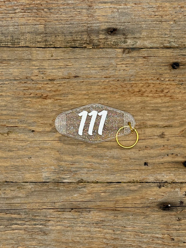 Clear keychain with number '111' on a wooden surface
