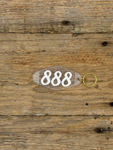 Keychain with the number '888' on a wooden surface