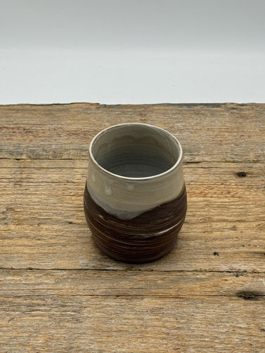 Ceramic cup with two-tone design on a wooden surface