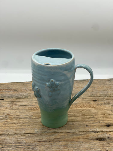 Ceramic mug with textured design on a wooden surface