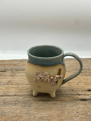 Ceramic mug with floral design on a wooden surface