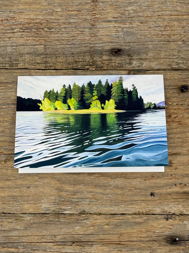 Painting of a forest reflected in water on a wooden surface