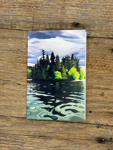 Painting of a forest reflected in water on a wooden surface
