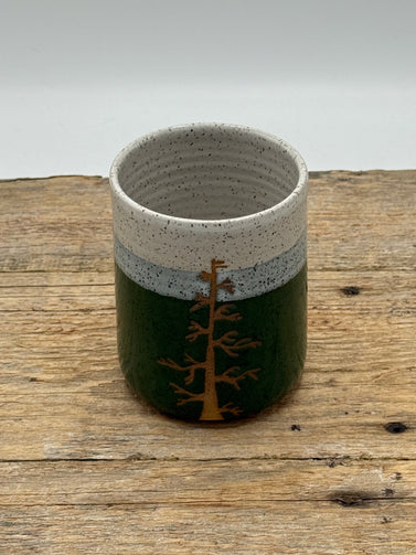 Ceramic cup with a tree design on a wooden surface