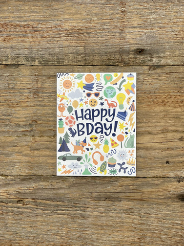 Card with 'Happy Bday!' text and various illustrations on a wooden surface