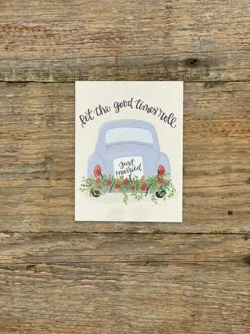Card with a blue car and 'Just Married' sign on a wooden surface
