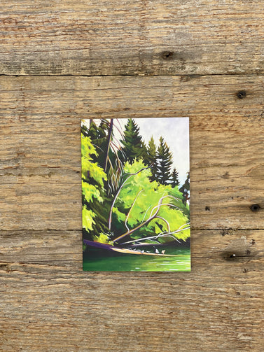 Small painting of a forest scene on a wooden surface