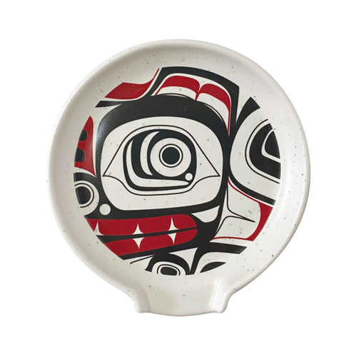 Ceramic plate with a n indigenous design in red, black, and white on a white background