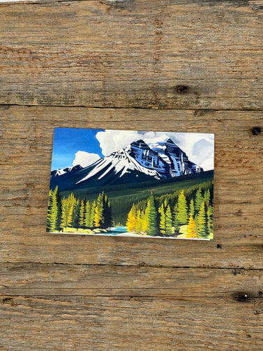 Greeting CArd with a mountain and forest design on a wooden surface
