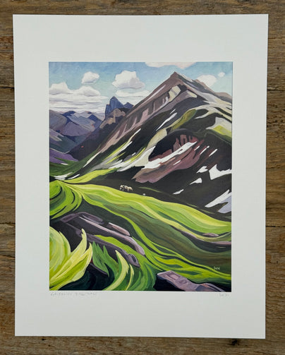 Painting of a mountain landscape with green valleys and purple mountains on a wooden surface.