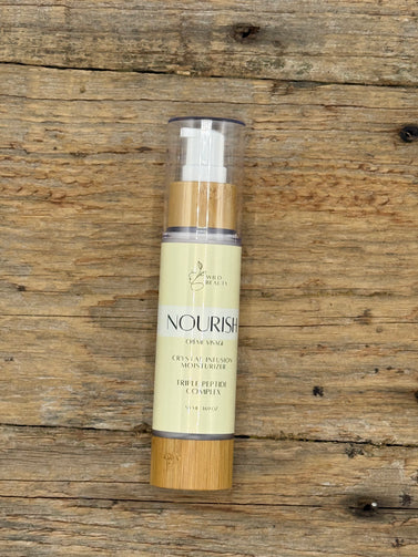Skincare serum bottle labeled 'Nourish' on a wooden surface
