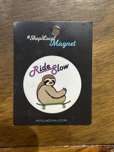 Ride slow sloth magnet on a black backing card with branding text.