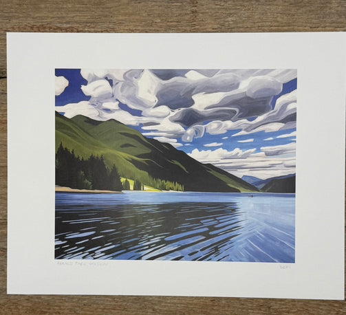 Print of a mountain landscape with a lake and blue sky.