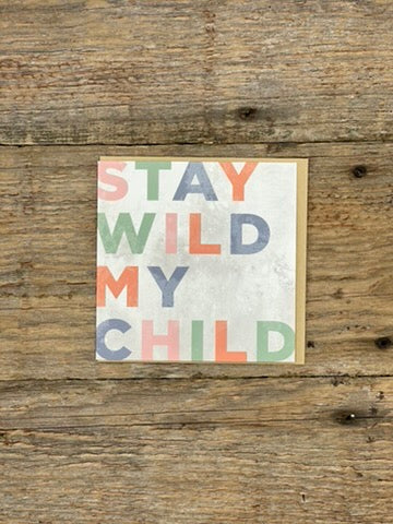 Card with 'Stay Wild My Child' text on a wooden surface