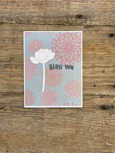 Card with floral design and 'Thank you' text on a wooden surface