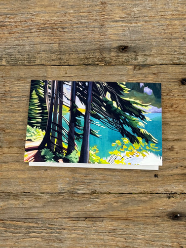 Greeting card with painting of a forest scene on a wooden surface