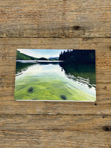 Painting of a lake scene on a wooden surface