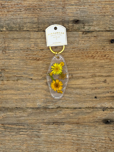 Clear keychain with yellow flowers on a wooden surface