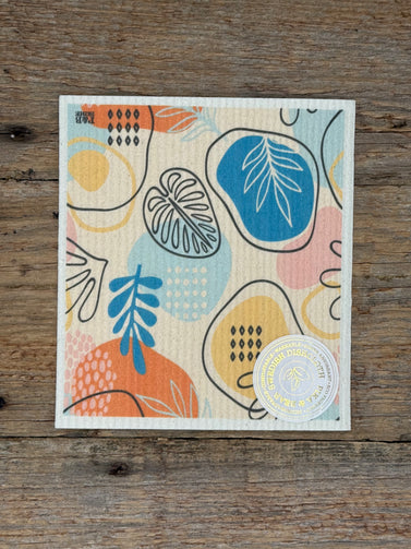 Colorful abstract design on cloth with a circular label on a wooden surface