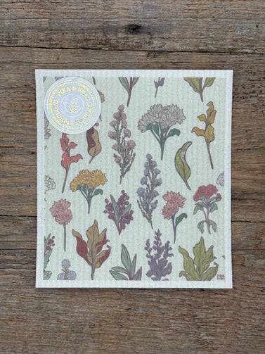 Floral-patterned cloth on a wooden surface with a visible brand label.