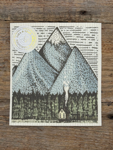 Stylized mountain illustration on a wooden surface with a brand logo.