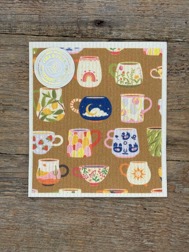 cloth with colorful mug illustrations on a wooden surface