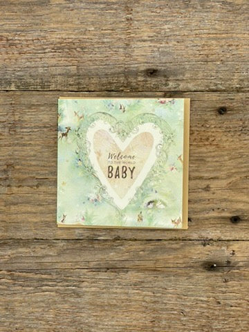 Greeting card with heart design and 'Welcome Baby' text on a wooden surface