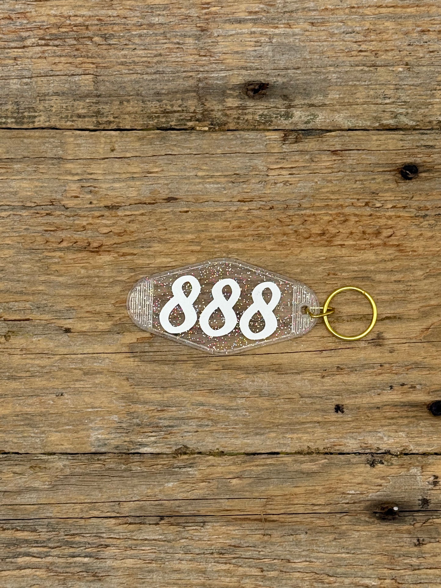 Keychain with the number '888' on a wooden surface