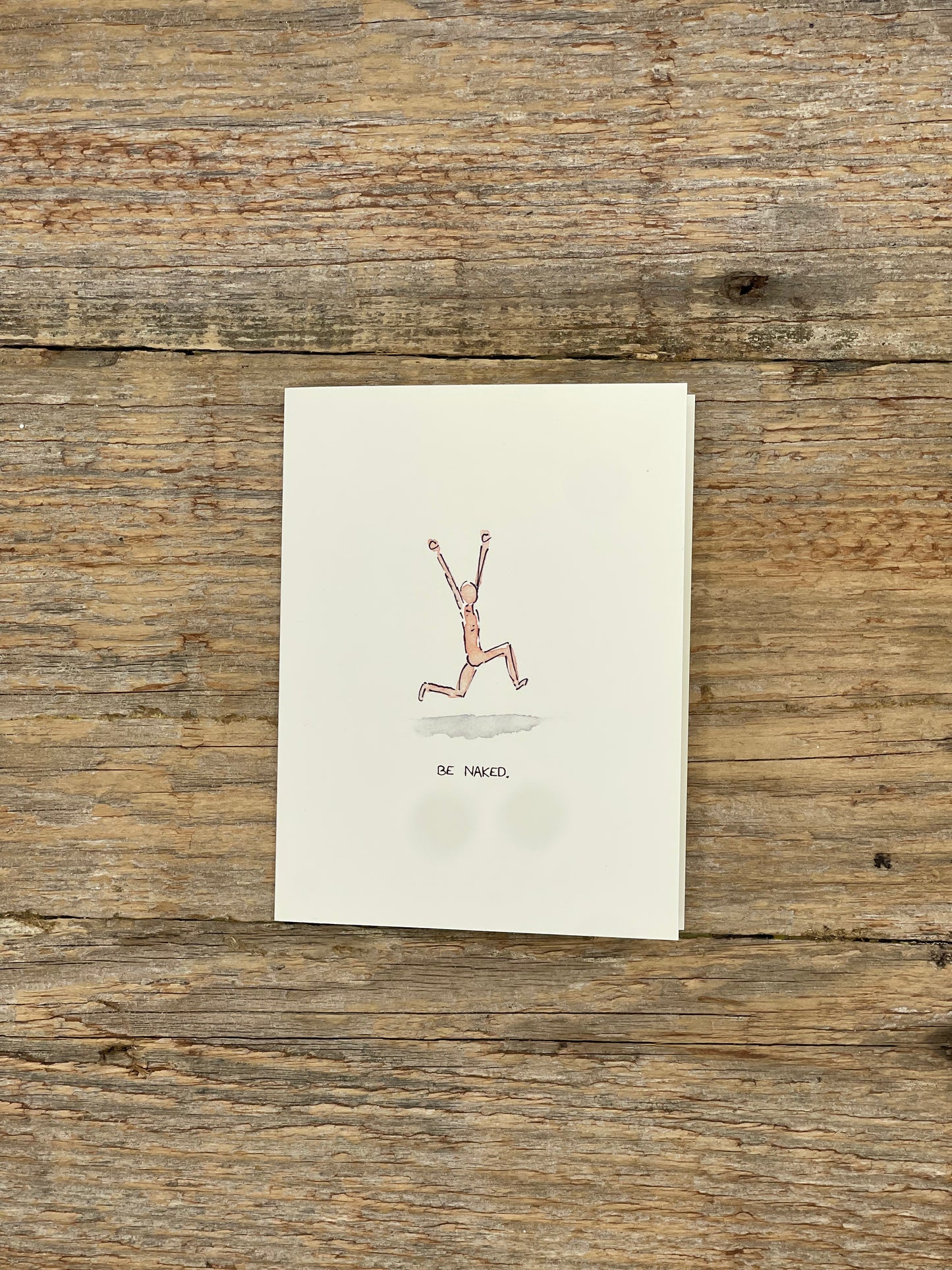 Note card with a drawing of a person running on a wooden surface
