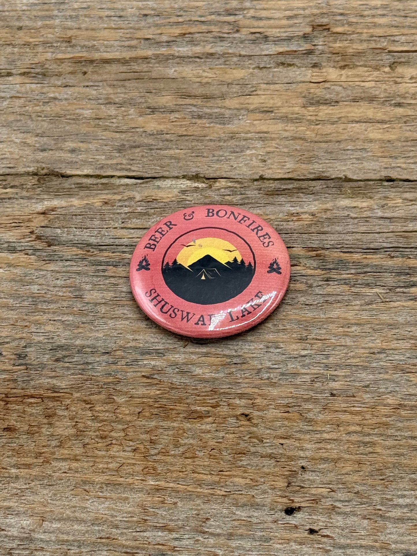 Orange Magnet with mountain design and text on a wooden surface