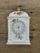 Decorative clock with floral designs on a wooden background