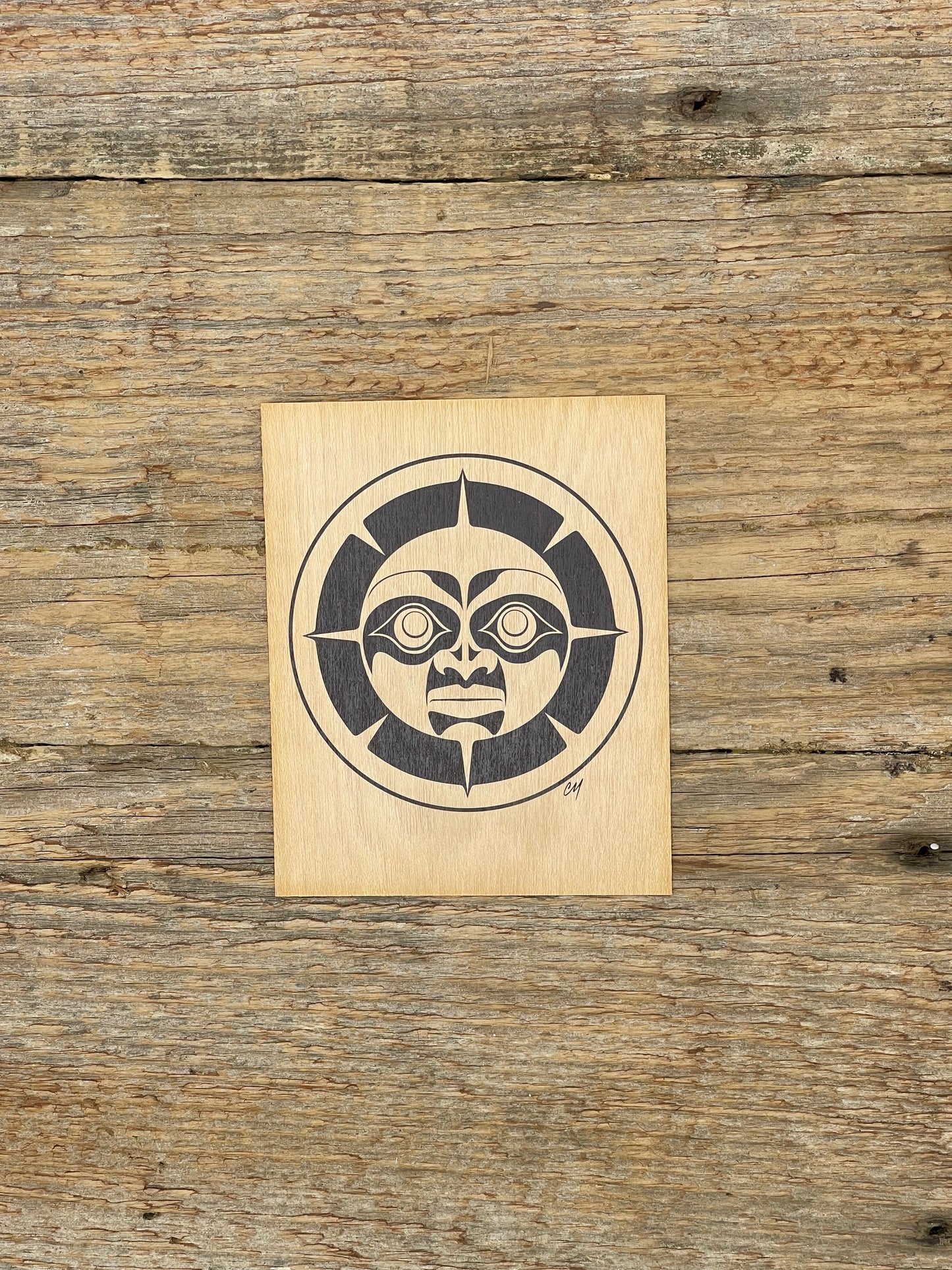 Wooden block with a Haida Moon design on a wooden surface