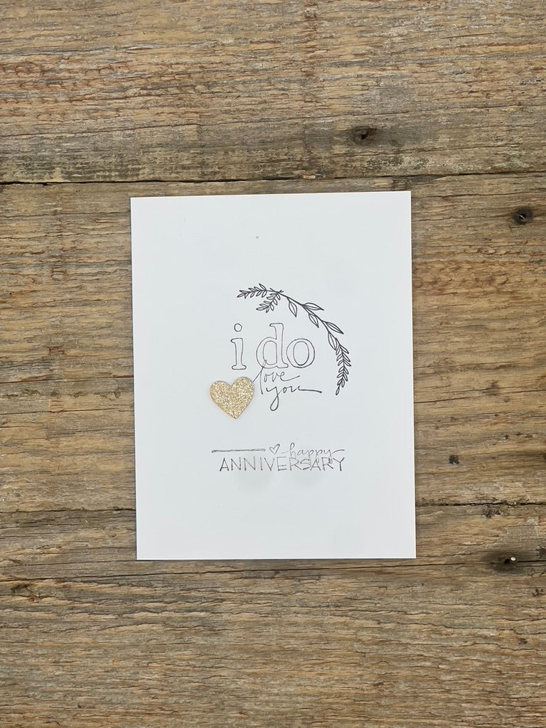 White card with 'i do love you' text and heart on a wooden surface