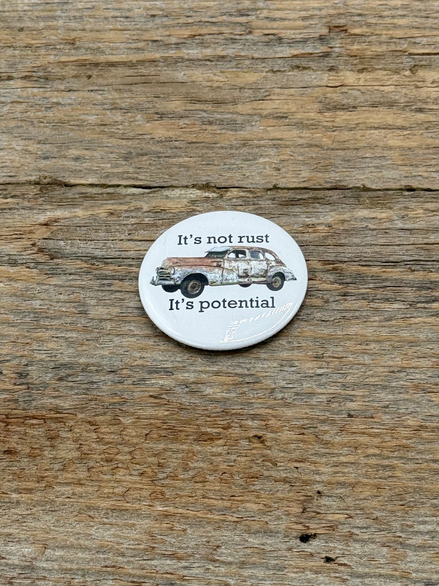 Circular sticker with vintage car illustration and text on a wooden surface