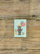Small birthday card with cartoon bears on a wooden surface