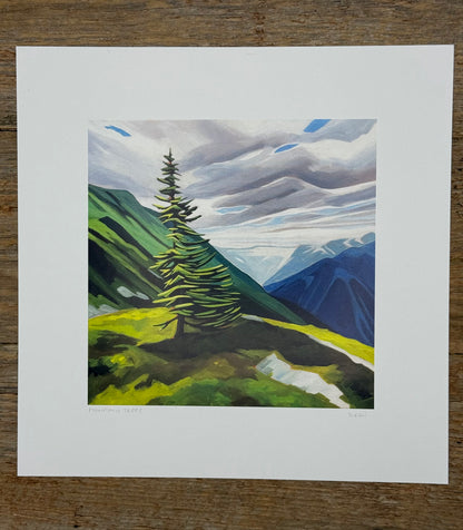 Painting of a mountain landscape with a prominent tree on a wooden surface
