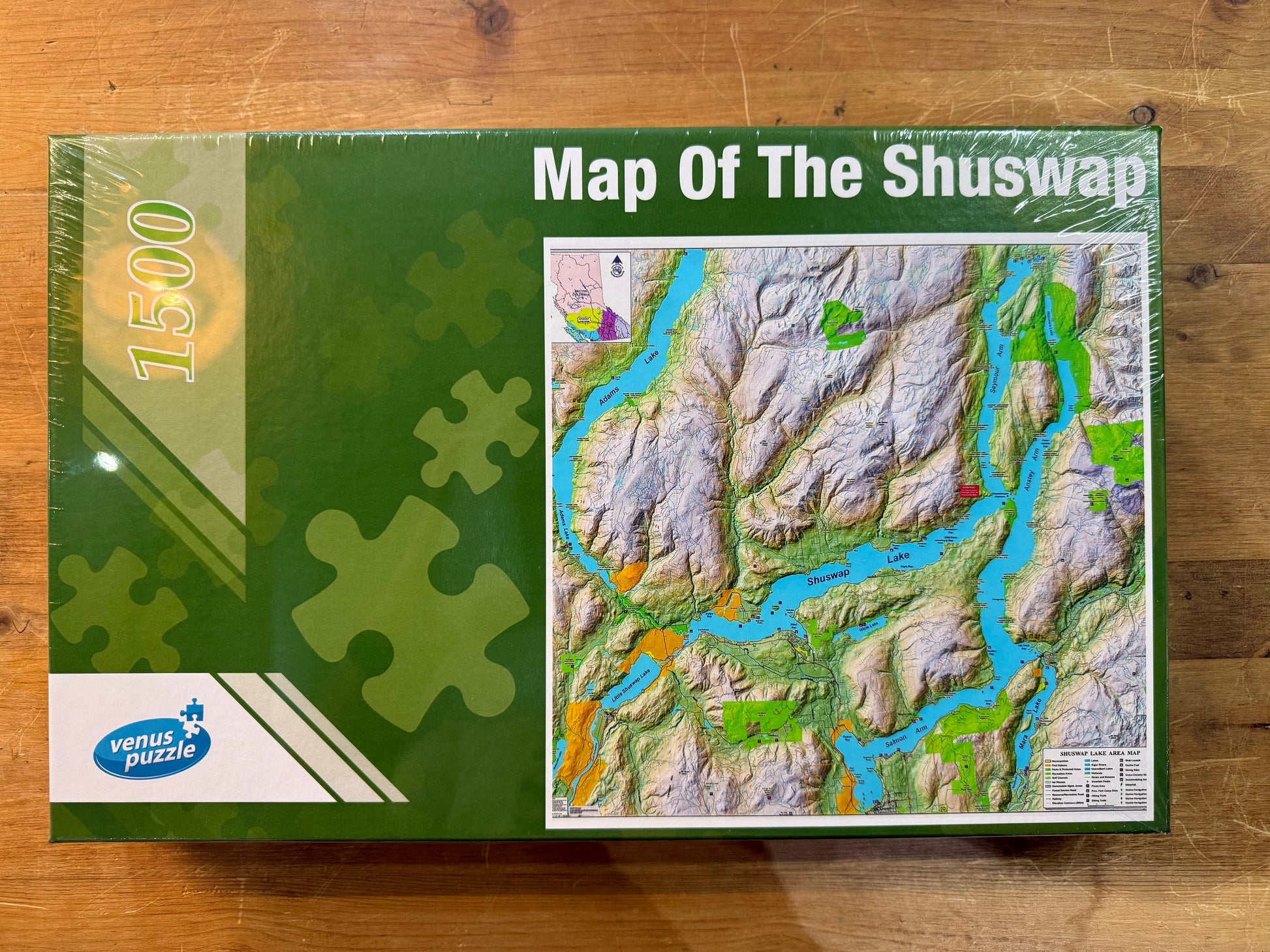 Venus Puzzle packaging of 'Map Of The Shuswap' on a wooden surface