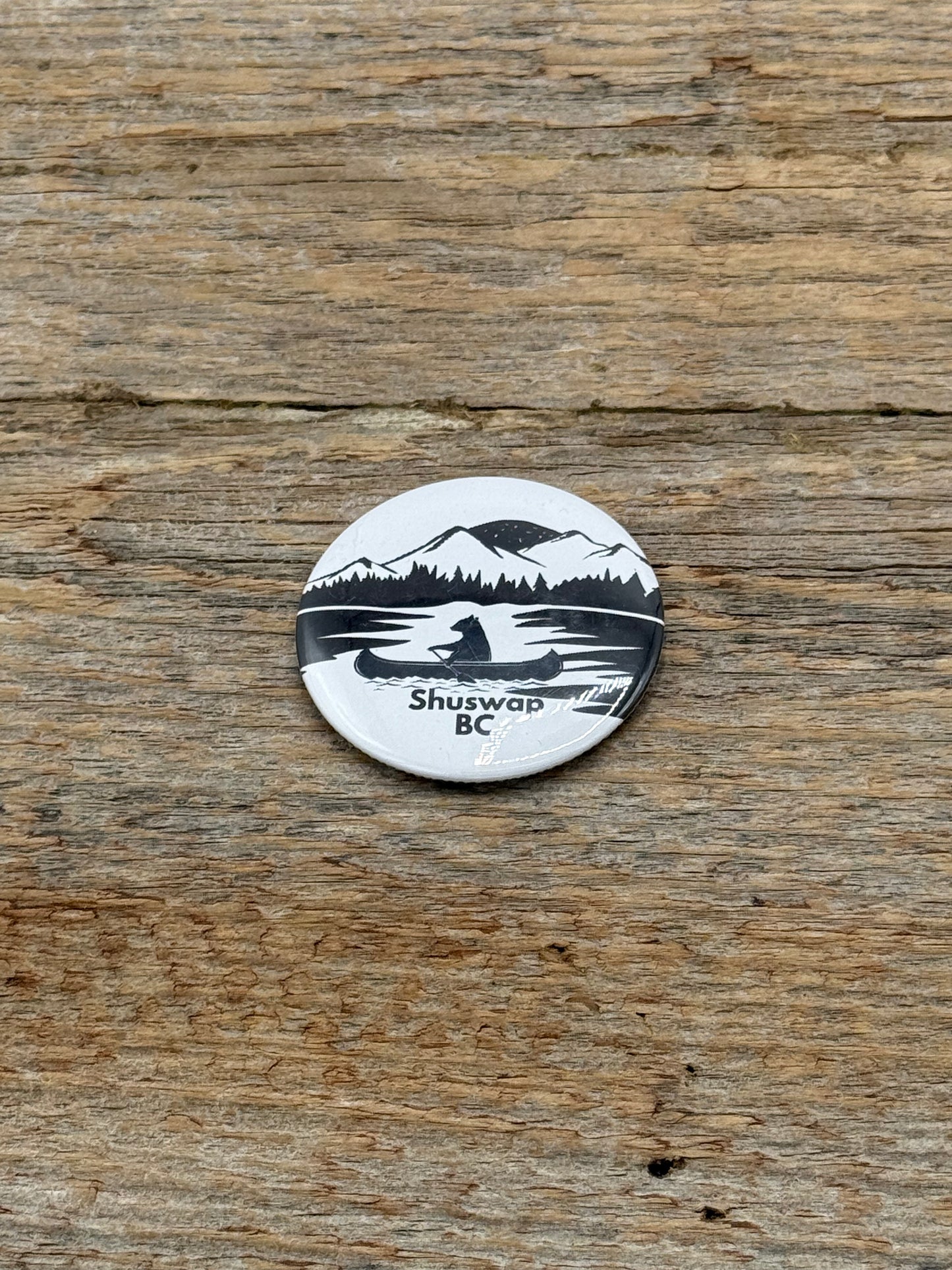 Round white sticker with black and blue design on a wooden surface