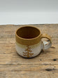 Ceramic mug with a tree design on a wooden surface