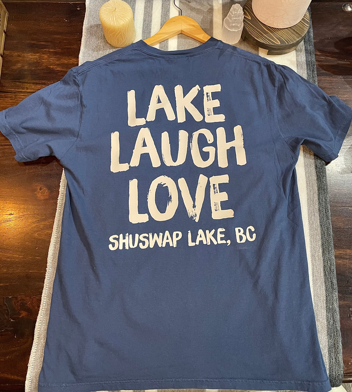 blue t-shirt with white graphic writing that says "LAKE LAUGH LOVE, SHUSWAP LAKE, BC"
