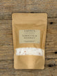 Tappen Apothecary Tobacco & Whiskey bath salts packaging on a wooden surface