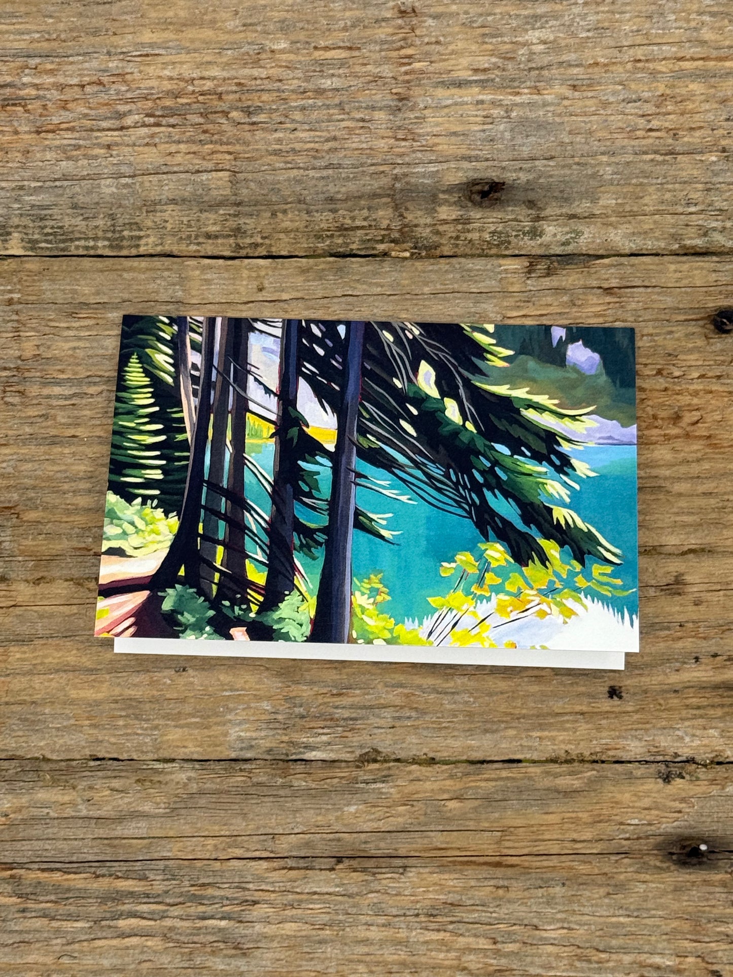 Greeting card with painting of a forest scene on a wooden surface