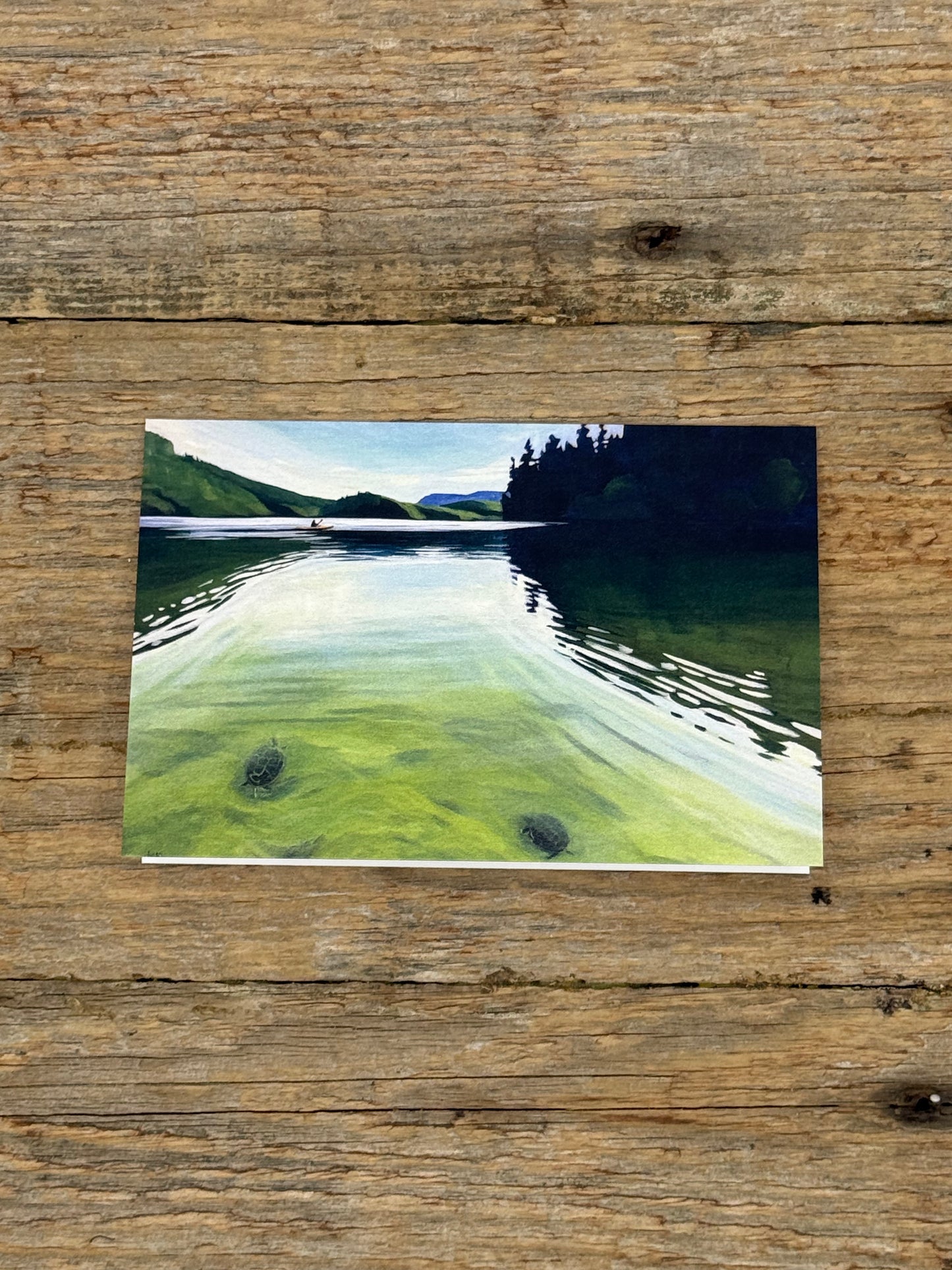 Painting of a lake scene on a wooden surface