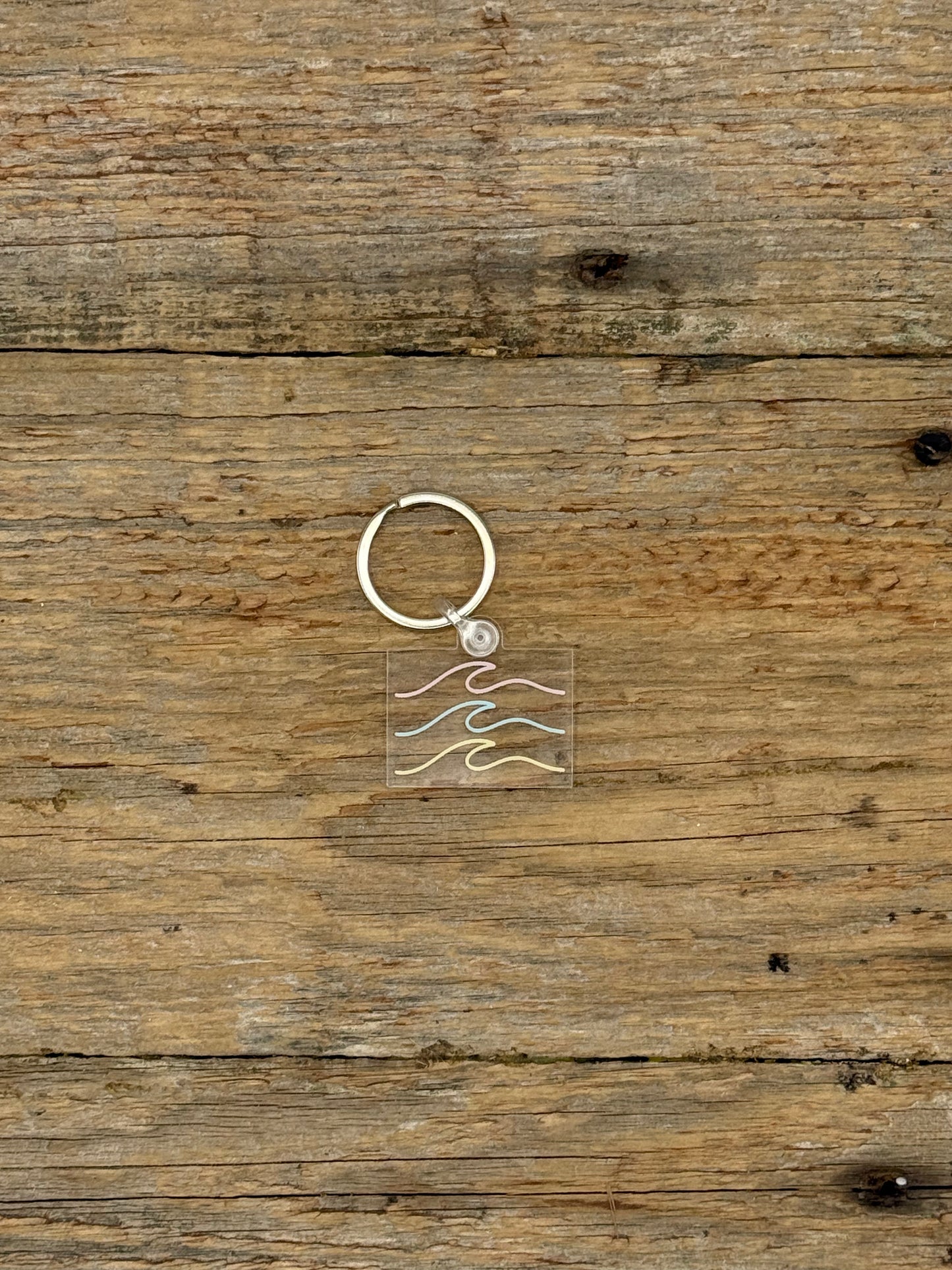 Keychain with a wave design on a wooden surface