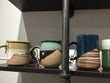 Collection of ceramic mugs on a shelf with a neutral background