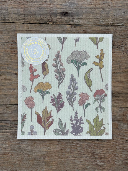 Floral-patterned cloth on a wooden surface with a visible brand label.