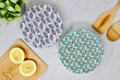 Reusable fabric bowl covers. one blue leaf pattern and other with a green speckled design. 